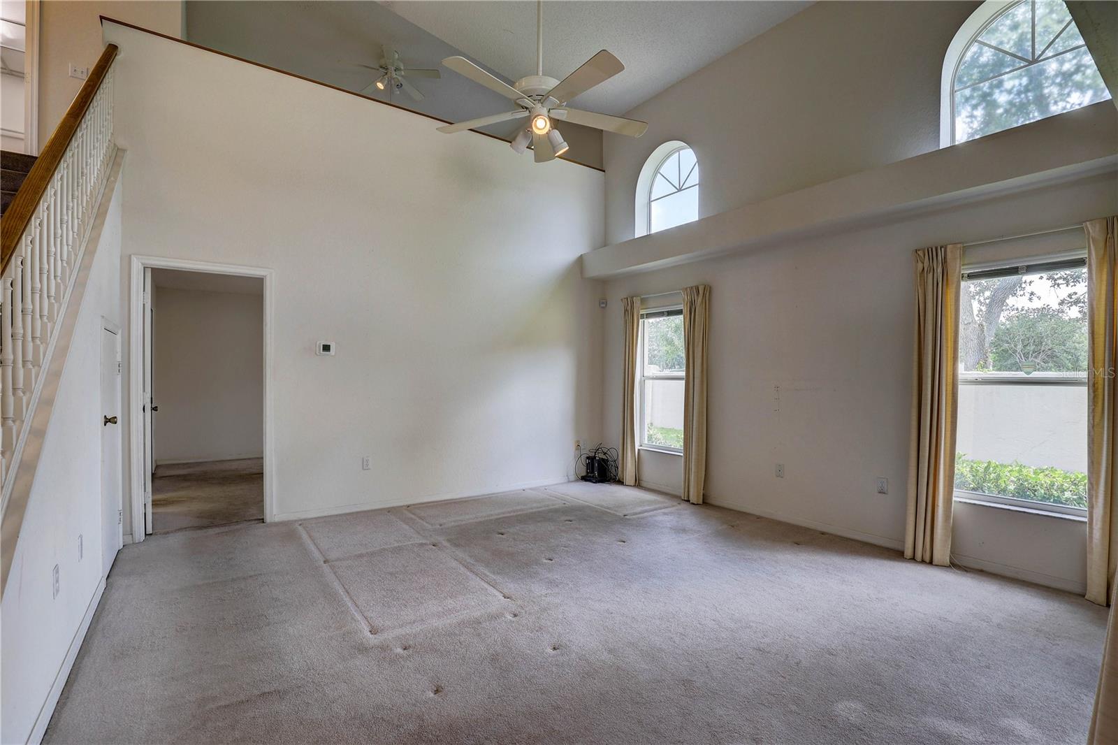 High ceilings and lots of windows in living room. Door to primary bedroom suite. Loft area on top