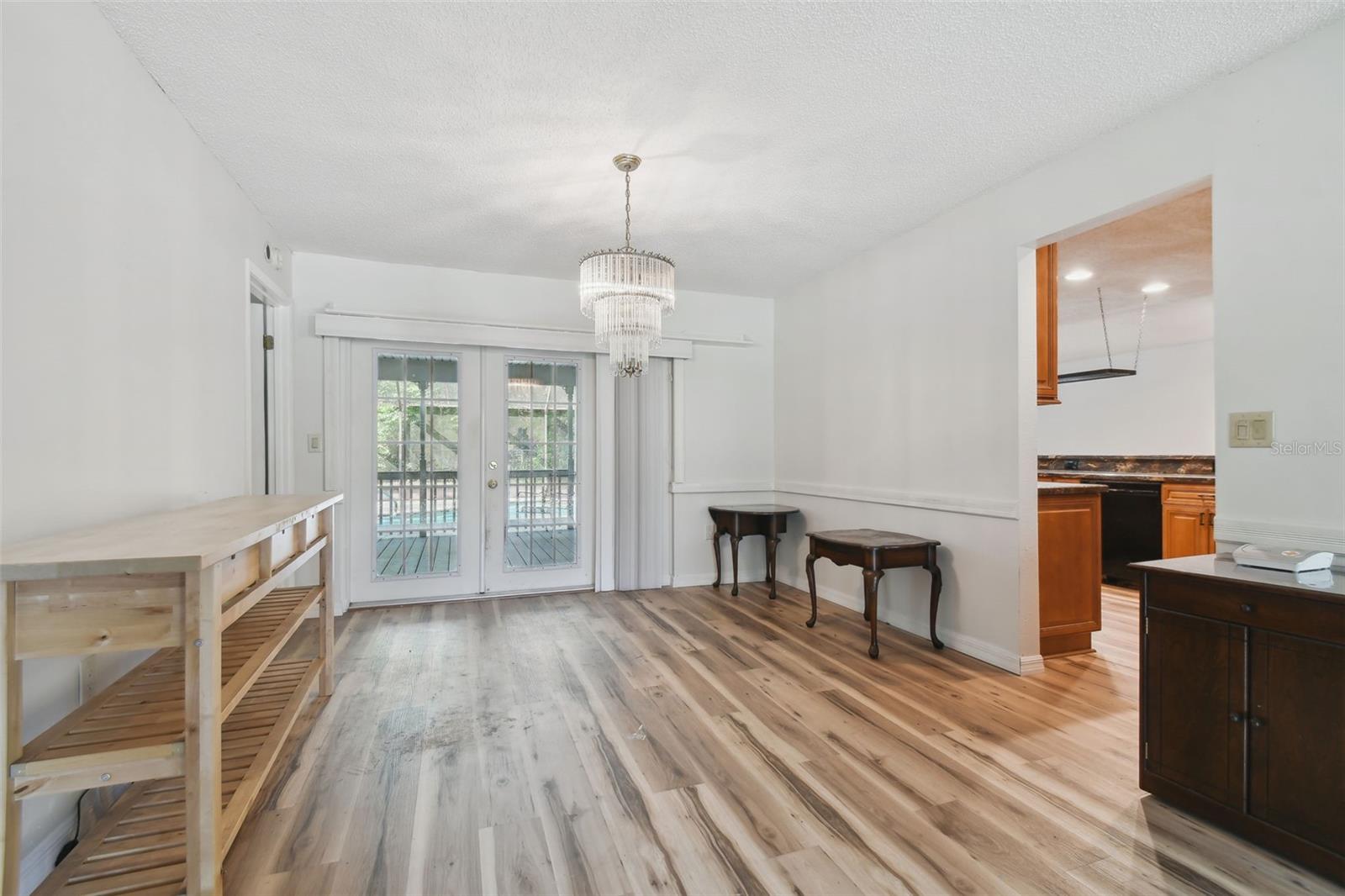 Formal dining with french doors to covered deck. Door to left is the entrance to primary suite.
