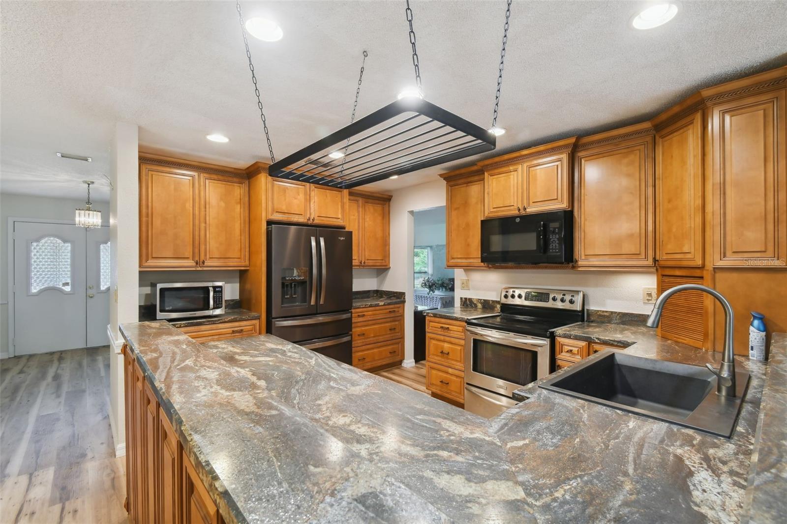 Custom cabinetry in a central kitchen...open to breakfast area and family room. Pull outs and newer refrigerator, dishwasher and microwave above range.