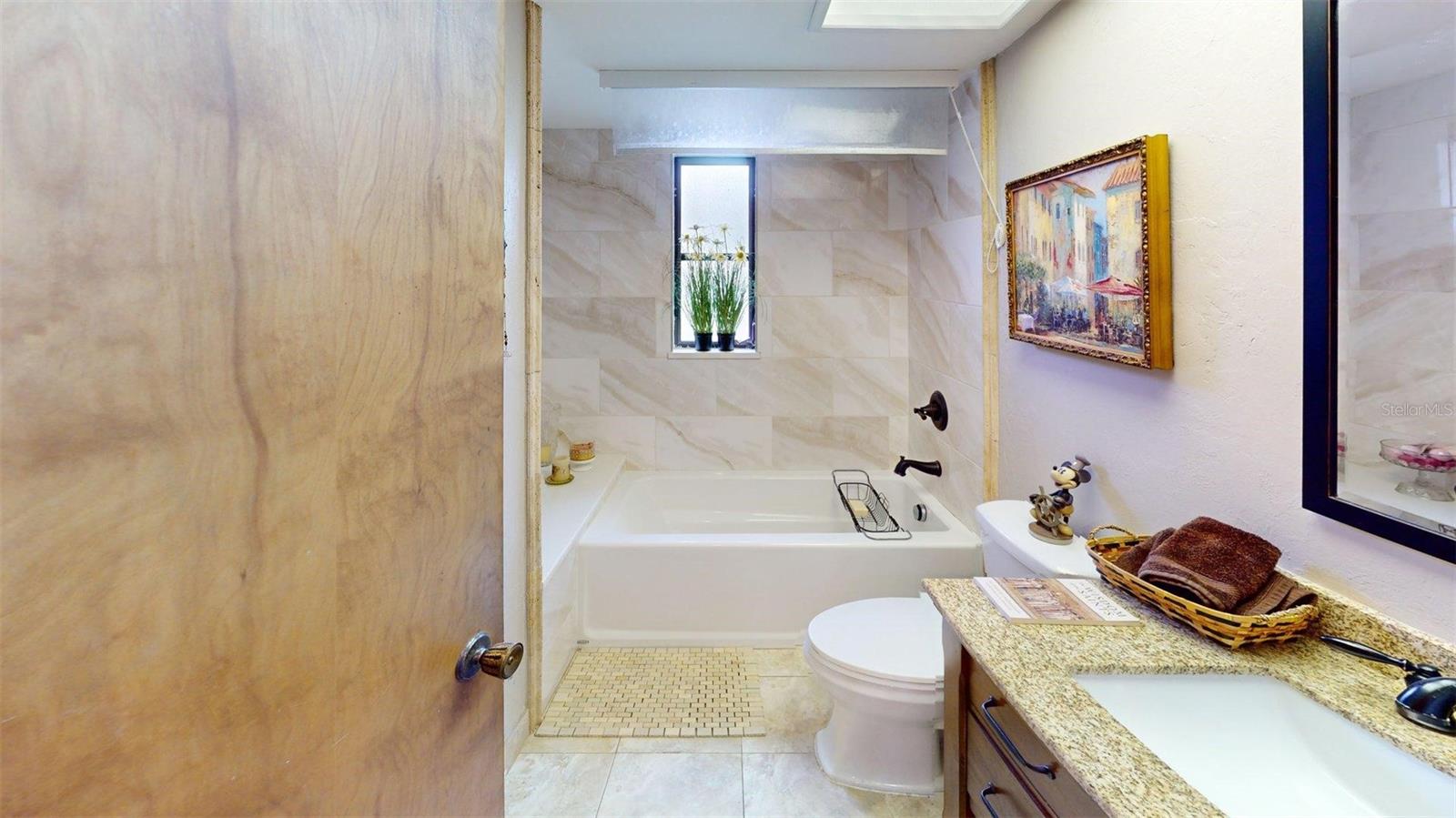 Full secondary bath with pull down shower curtain.