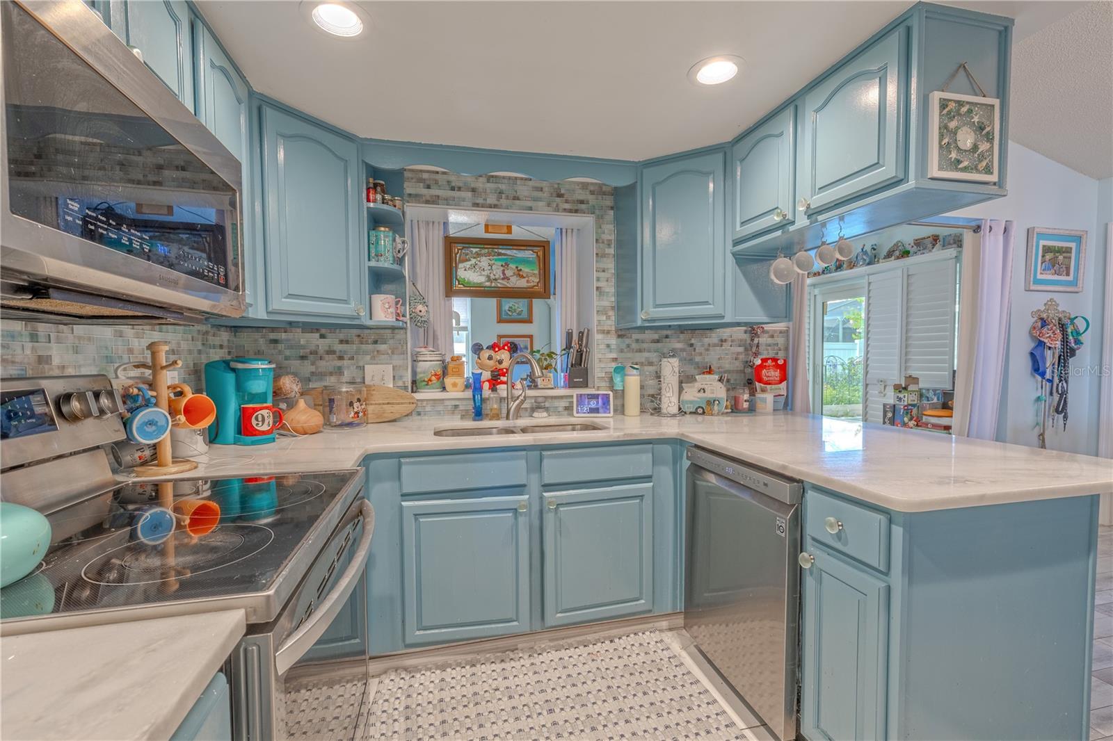 This cheerful and functional kitchen offers the perfect blend of style and efficiency. Crisp marble-look countertops provide generous prep space, while a full suite of stainless steel appliances—including a smooth-top range and built-in microwave—makes cooking a breeze.