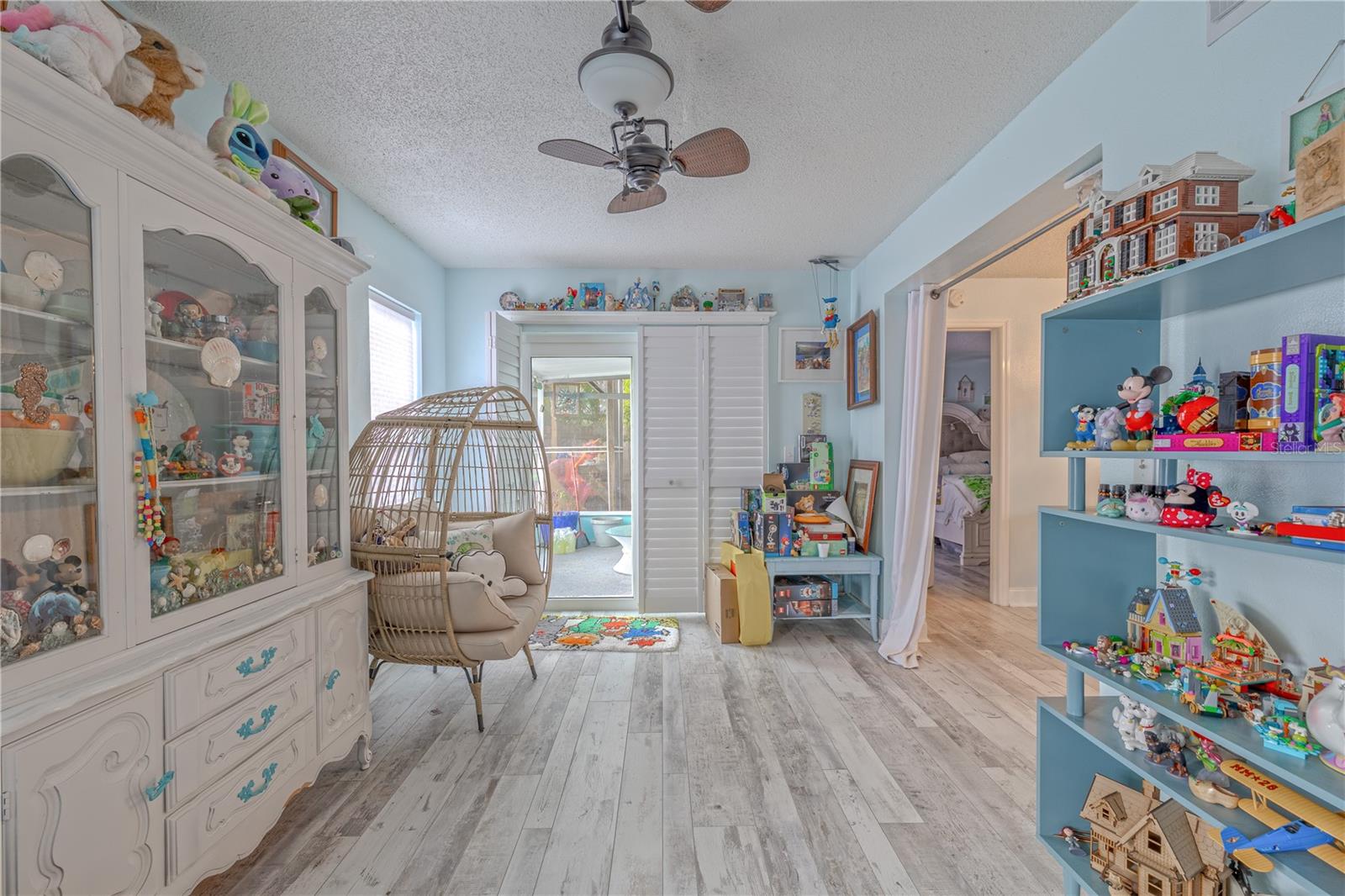 This versatile Florida room offers a bright and inviting space with plenty of natural light pouring in through multiple windows and sliding glass doors.