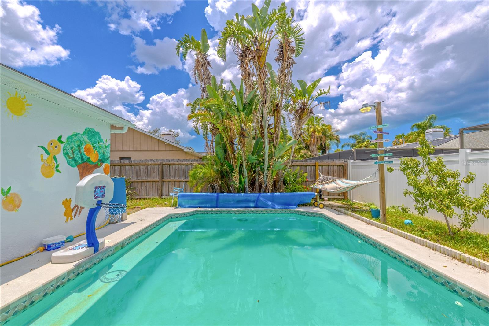 Enjoy endless days of sun and relaxation in your private, heated pool—an inviting retreat right in your own backyard. Surrounded by tropical landscaping and fully enclosed by fencing, this sparkling in-ground pool offers both privacy and tranquility.