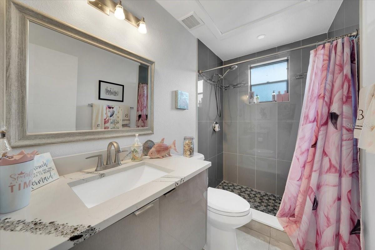 Guest bathroom with stand in shower and floating vanity
