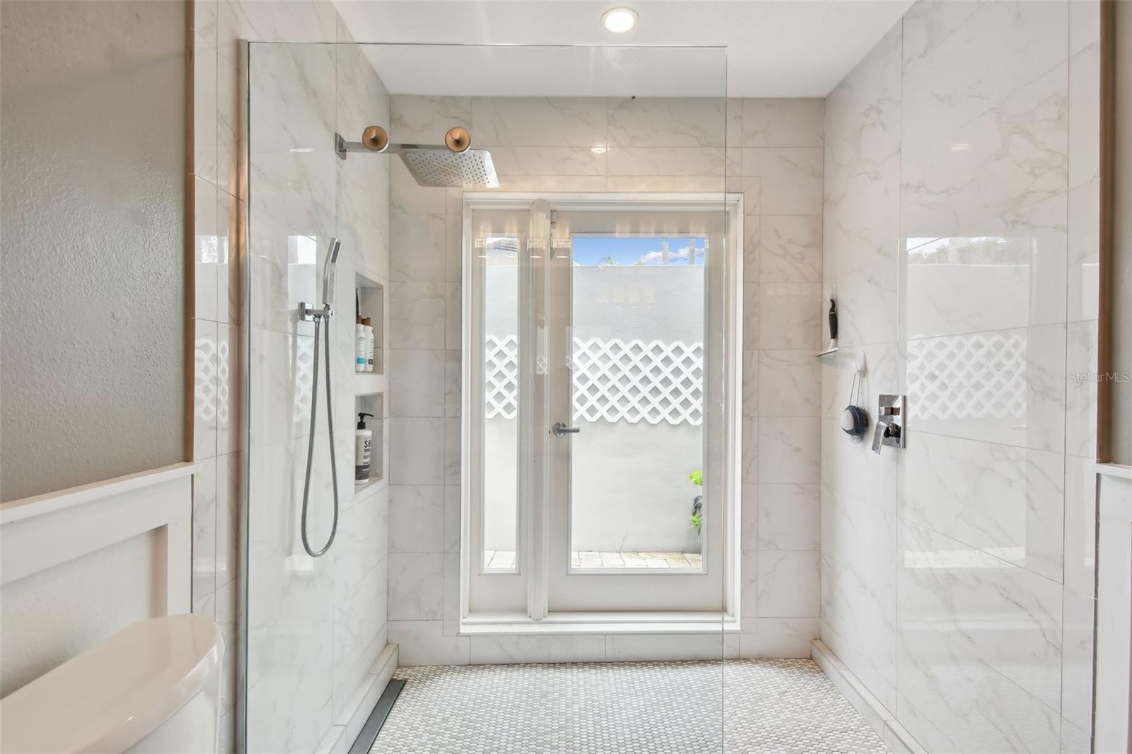 Huge shower with multiple sprays, including rain-forest shower head. Gleaming decorator tiles. Access to a private  sunbathing area.