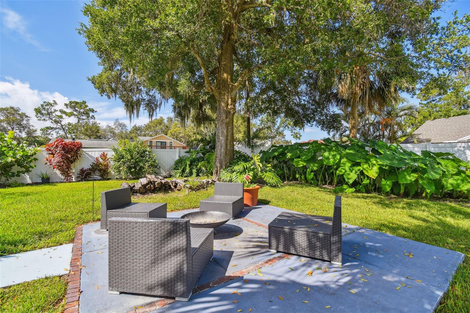 Fire pit surrounded by lush landscaping.