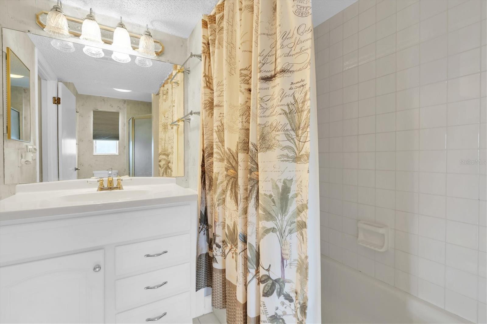 En suite bathroom with a bathtub and vanity