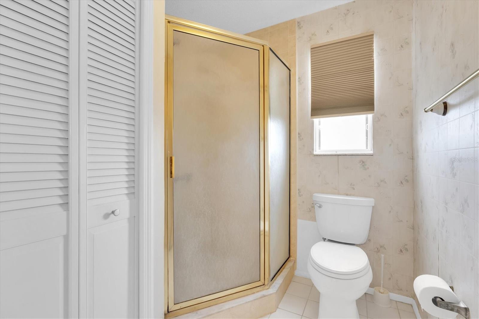 En suite bathroom with an additional linen closet and separate stand up shower