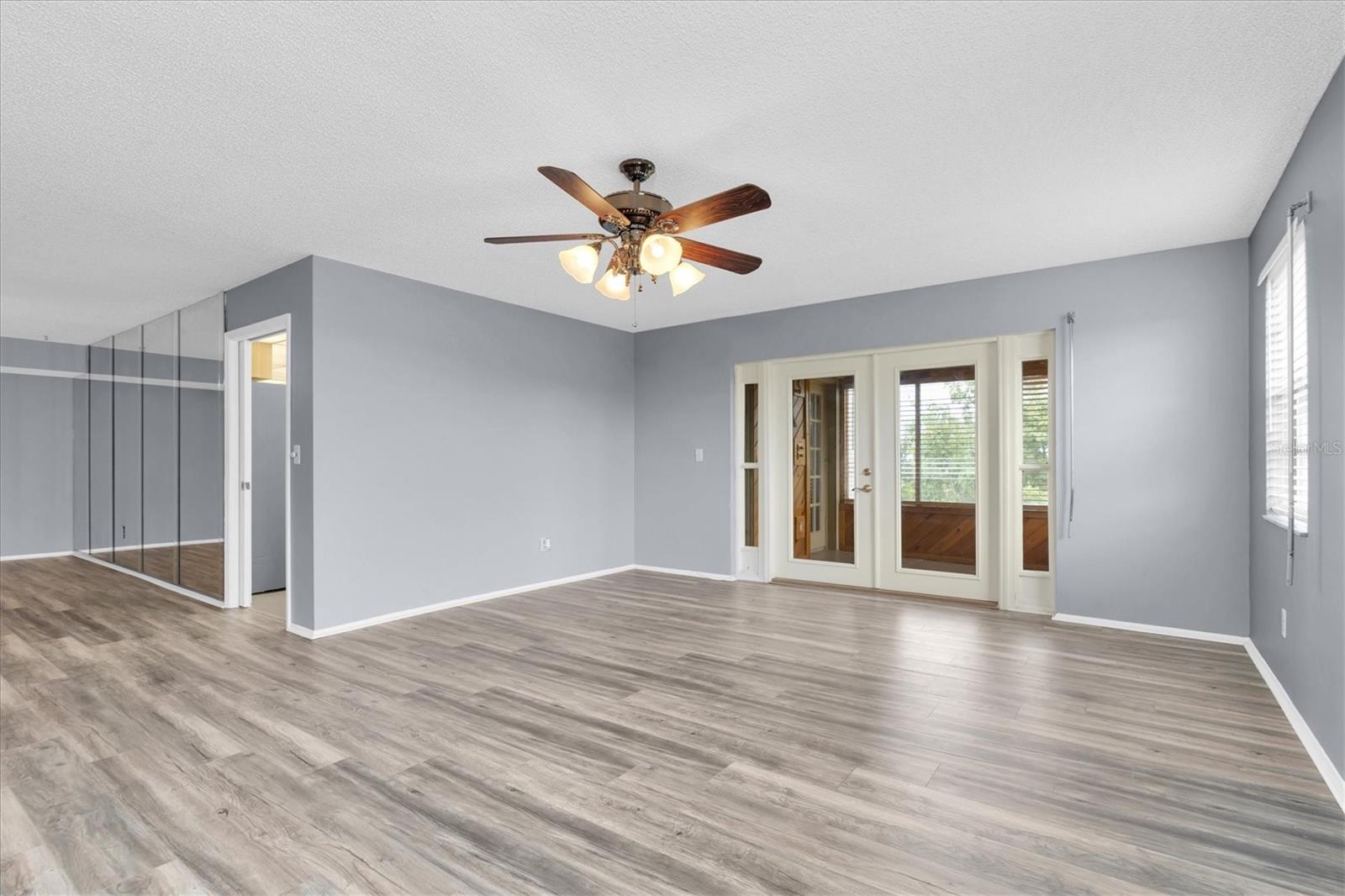 Living area with the doorway into the kitchen and French doors leading to the all season patio.
