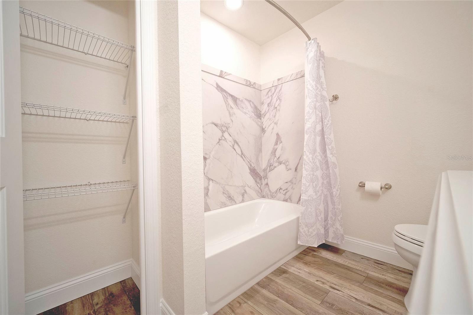Guest Bathroom with Tub/Shower combo and Linen closet.