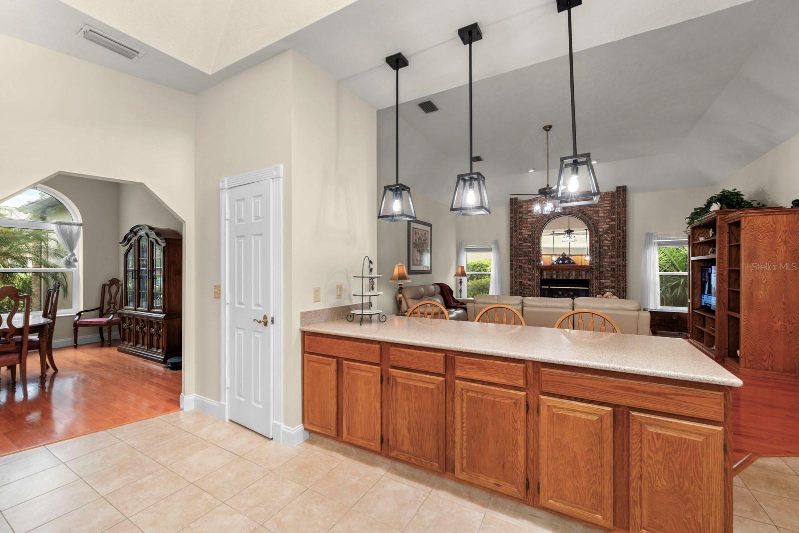 This classically beautiful kitchen features top-tier granite countertops, newer stainless appliances, solid wood cabinets, a newer stainless sink, a skylight above, new recessed lighting was added, ceramic tile flooring, and was opened up to the Great Room with updated pendant lights added.
