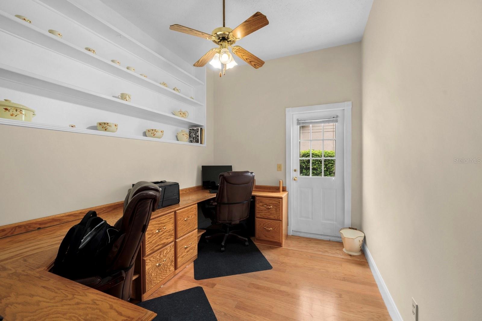 The office/bonus room features wood flooring and a lighted ceiling fan.