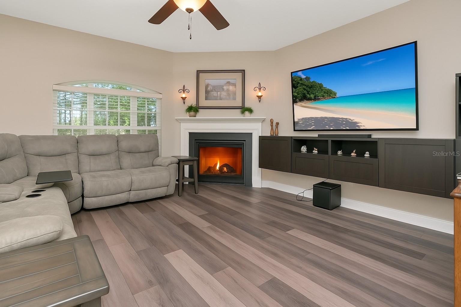 Living room with mounted shelving and TV that convey
