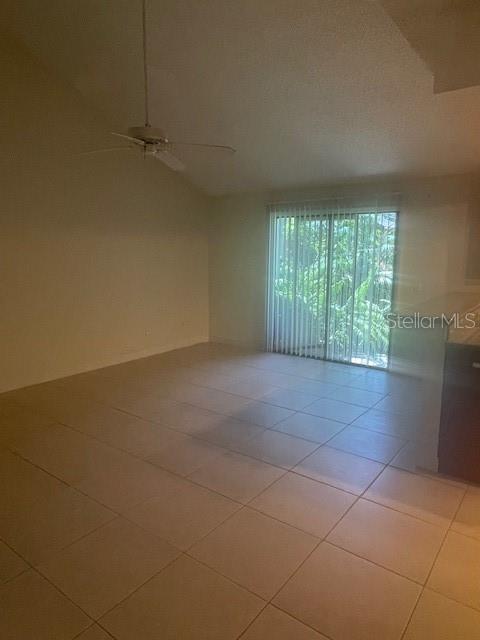 Great room w/ cathedral ceiling and glass sliders to private patio. Kitchen is on right.