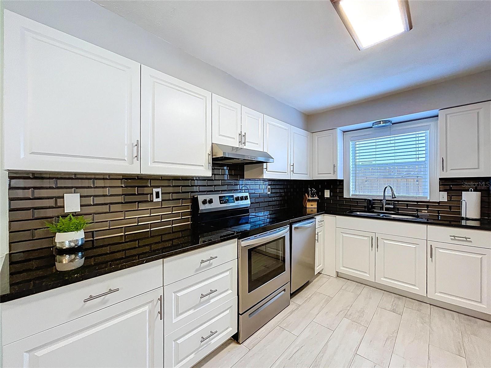 Updated kitchen with white cabinets and granite counter tops.