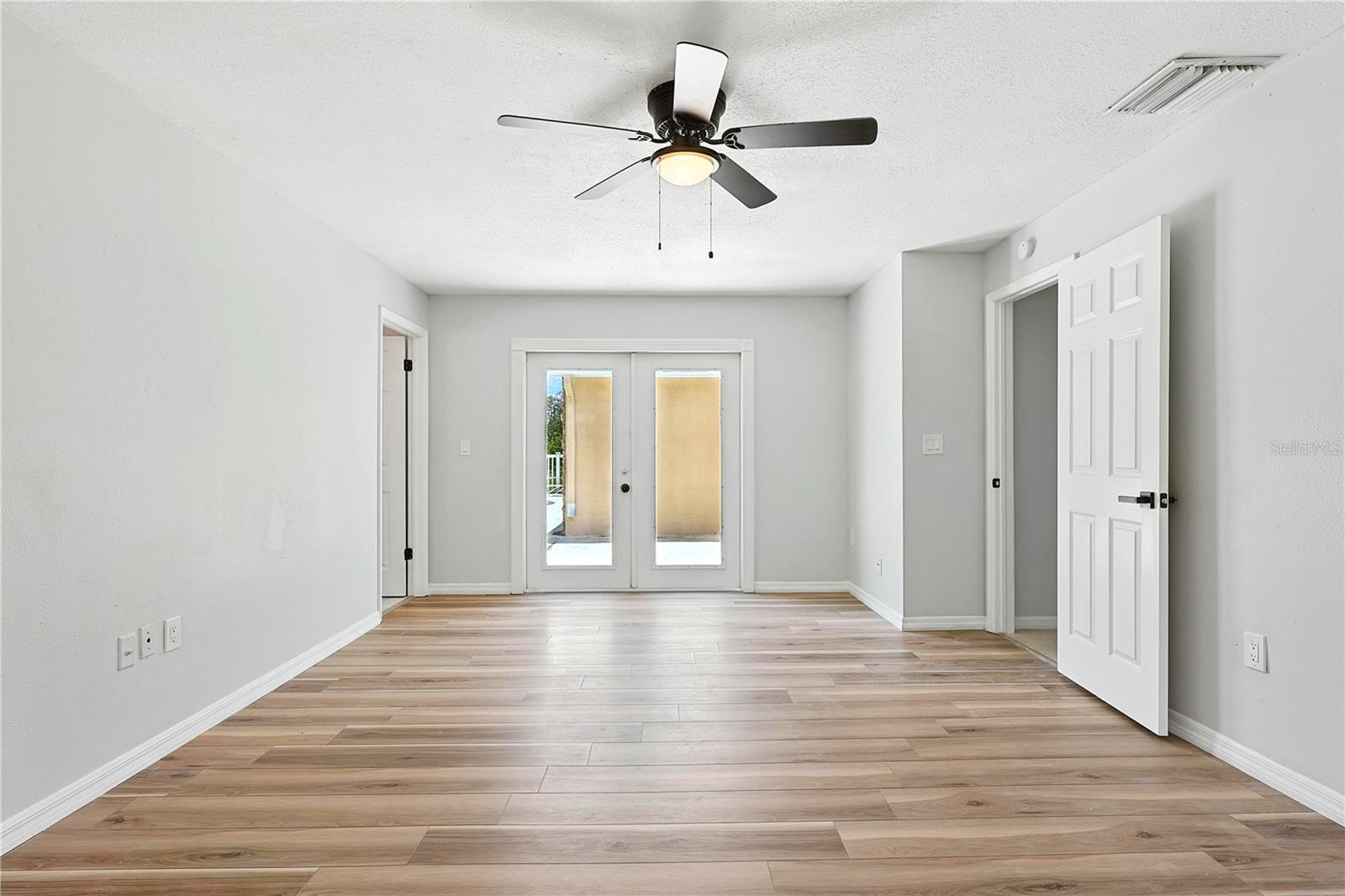Primary bedroom with doors leading to pool area