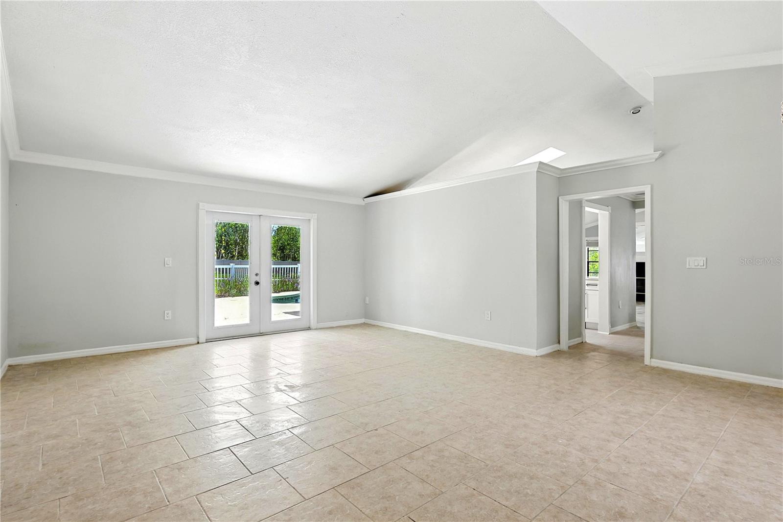 Living room with entry into kitchen and GlassDoor is leading to Pool