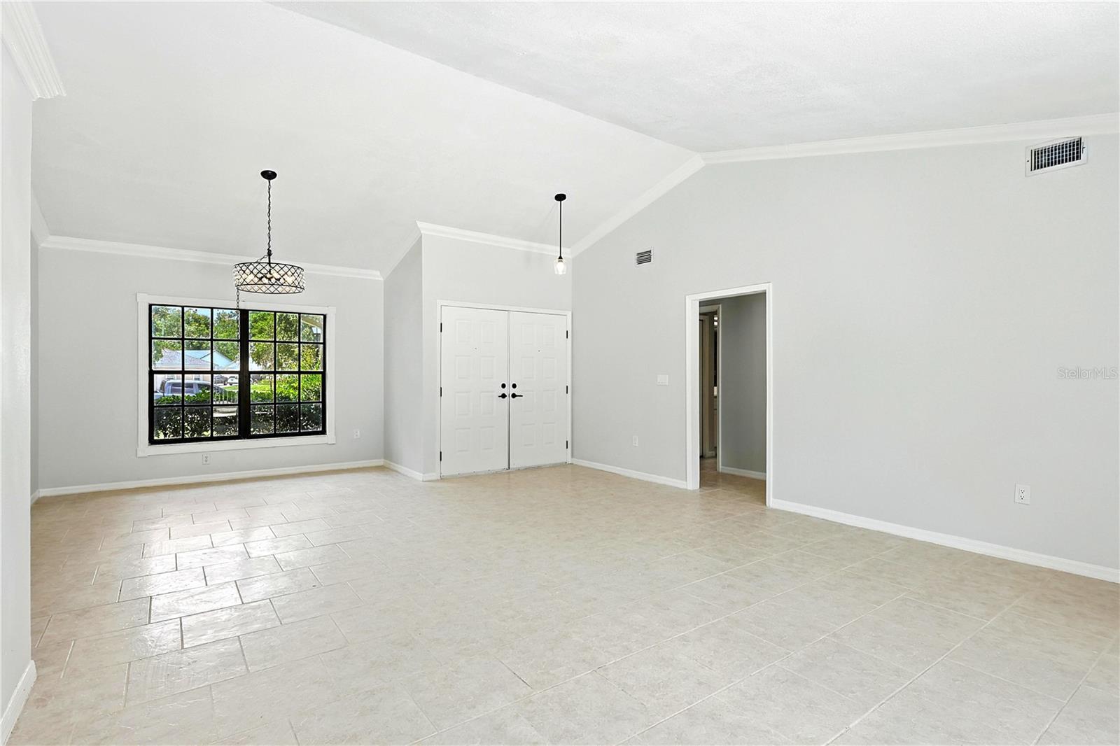 Dining room with windows, looking out to the front yard and double front entry door