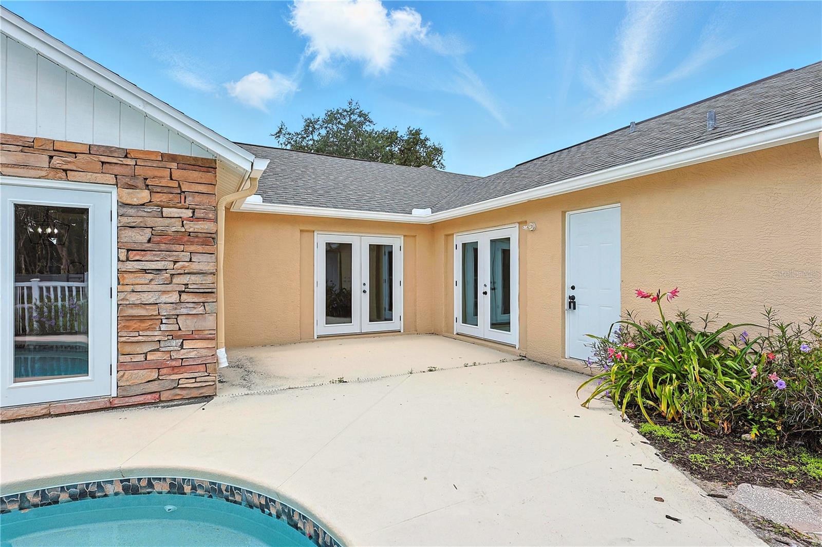 Outdoor pool area with glass doors to the master bedroom and to the living room
