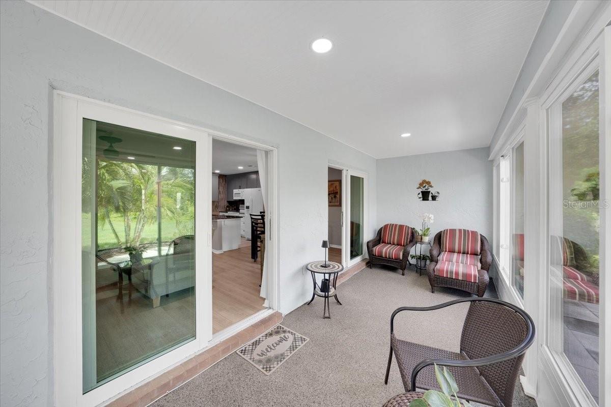 Enclosed lanai with 2 impact sliders leading from the home to the Sunroom