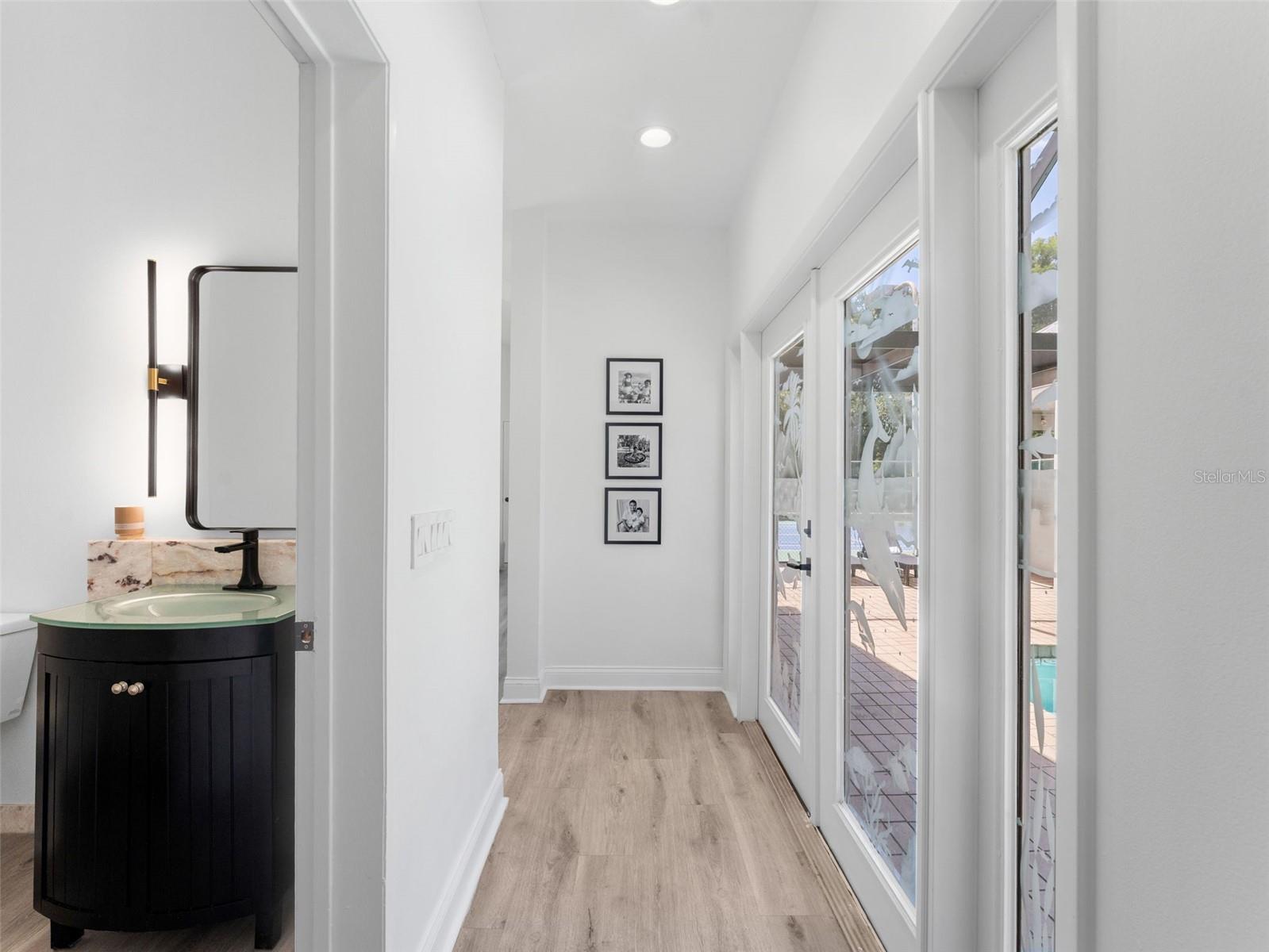 Powder Bath by pool entry and hallway to Family Room