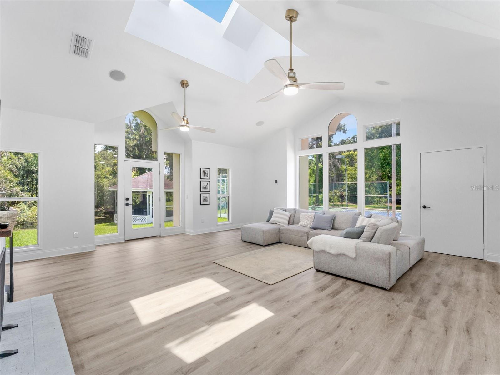 Grand family room with cathedral ceilings, tons of natural light and exits to the pool, gazebo or the tennis/pickball court