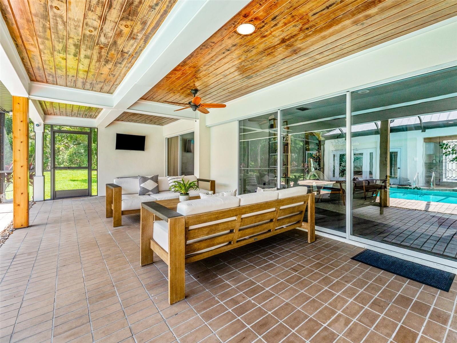 Stunning wood paneled ceiling and relaxing shaded lounge area outside of the formal Living Room