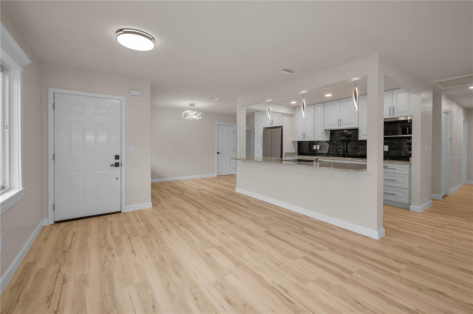 Looking back from great room to front door and open kitchen and dining
