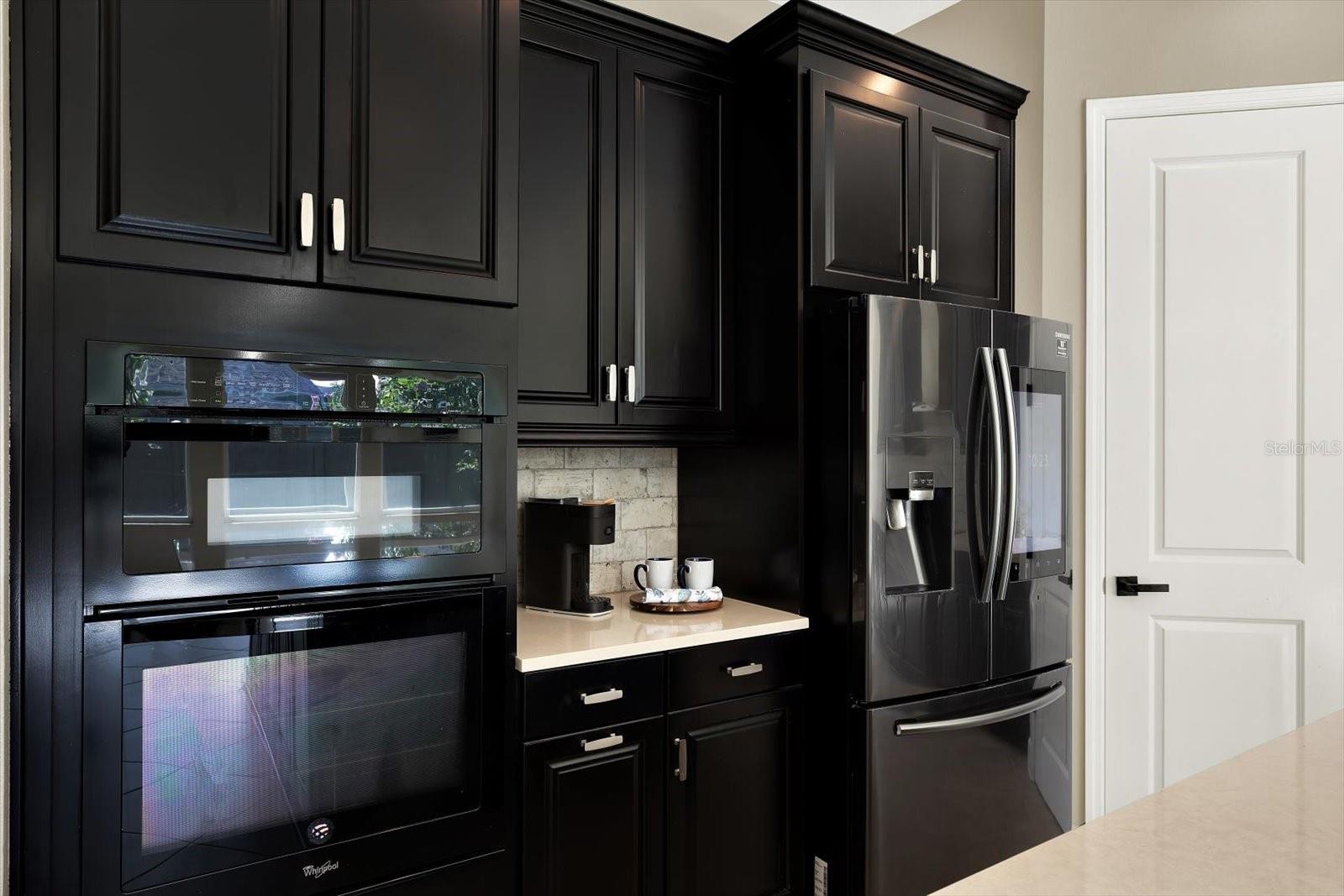 Sleek black appliances compliment the ebony cabinets