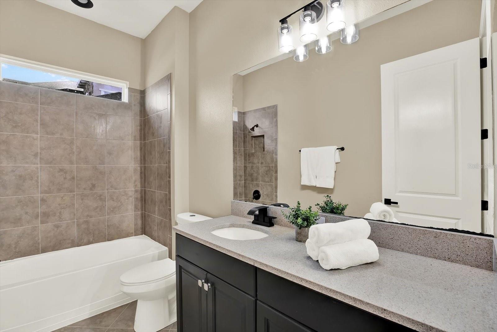 Bathroom 2 sits between bedrooms 2 and 3, and offers a shower/tub combo and large quartz countertop
