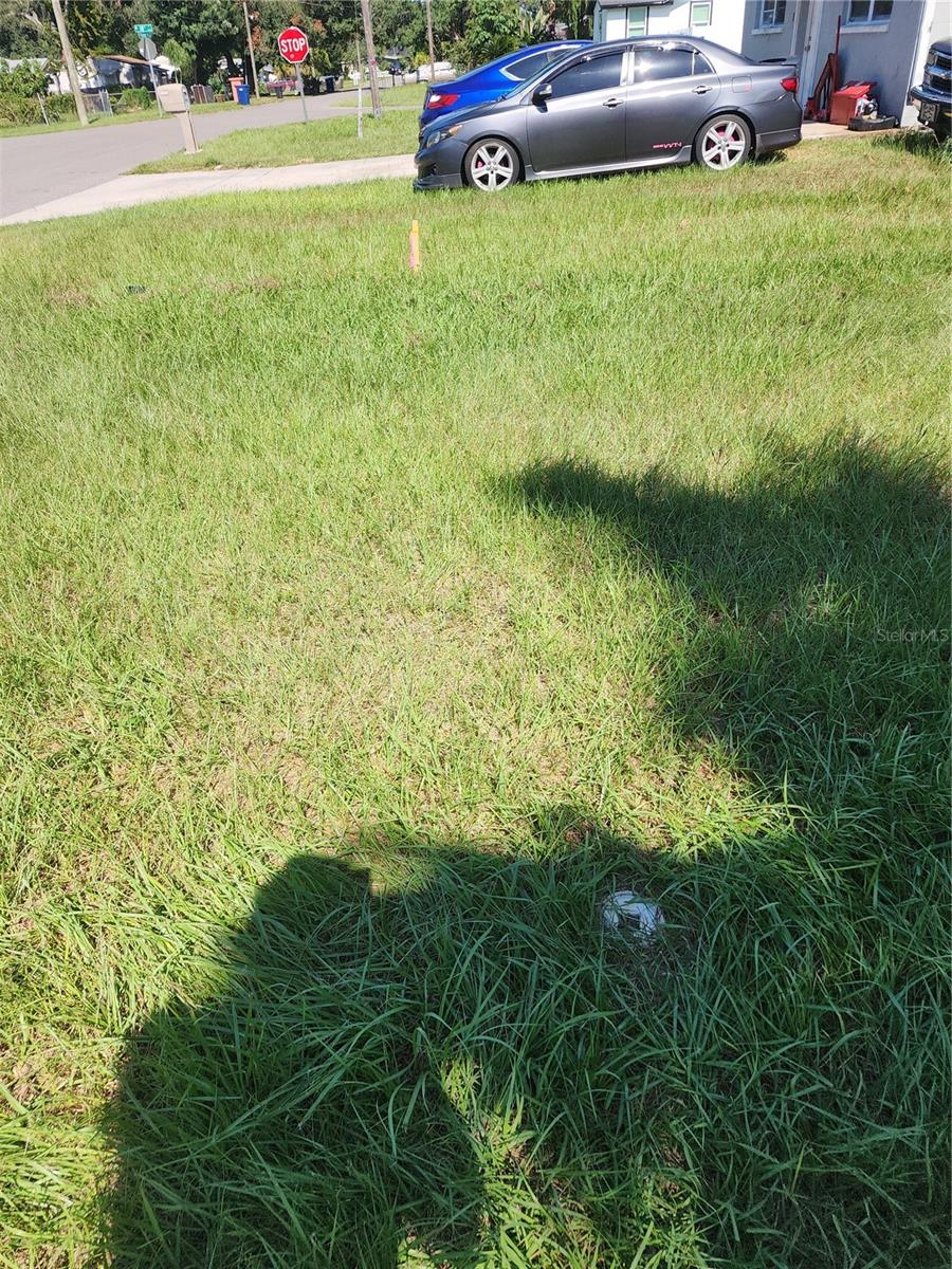 PVC Clean Out in Front Yard. 3 feet East of Driveway. 1 Ft inside Survey Marker.