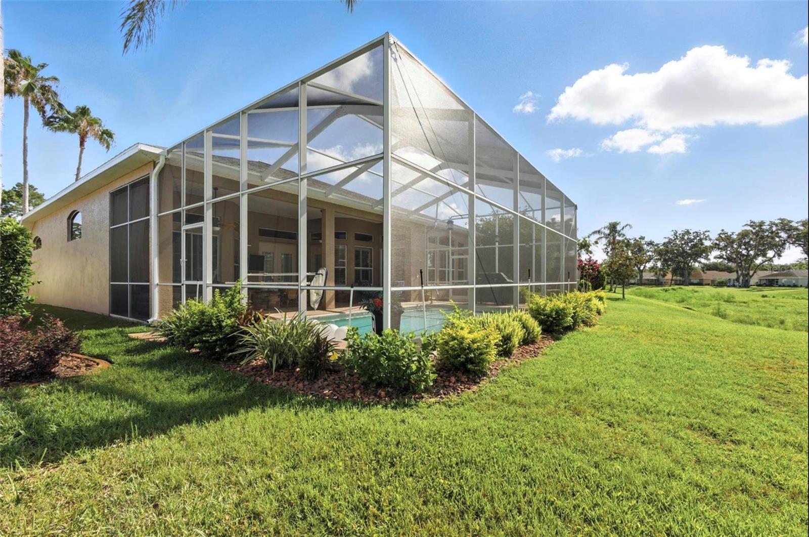 Backyard view of screened in pool