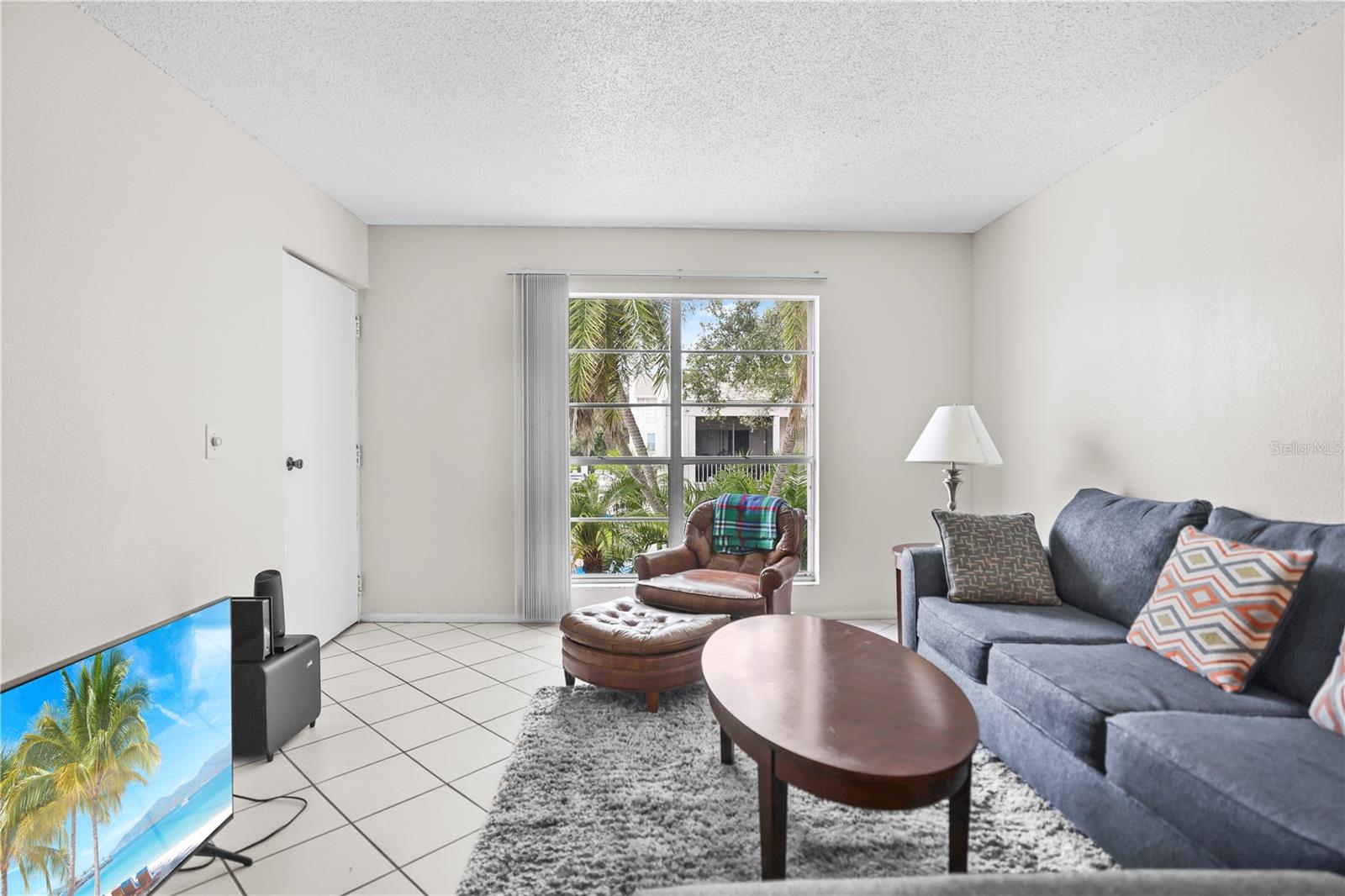 LIVING ROOM WITH VIEWS TO PALM TREES AND POOL