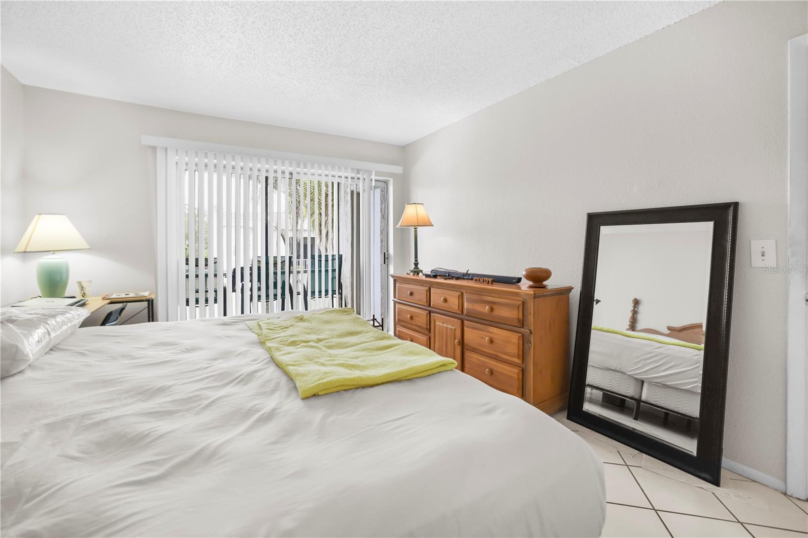 MASTER BEDROOM WITH SLIDERS TO PATIO AND POOL VIEW