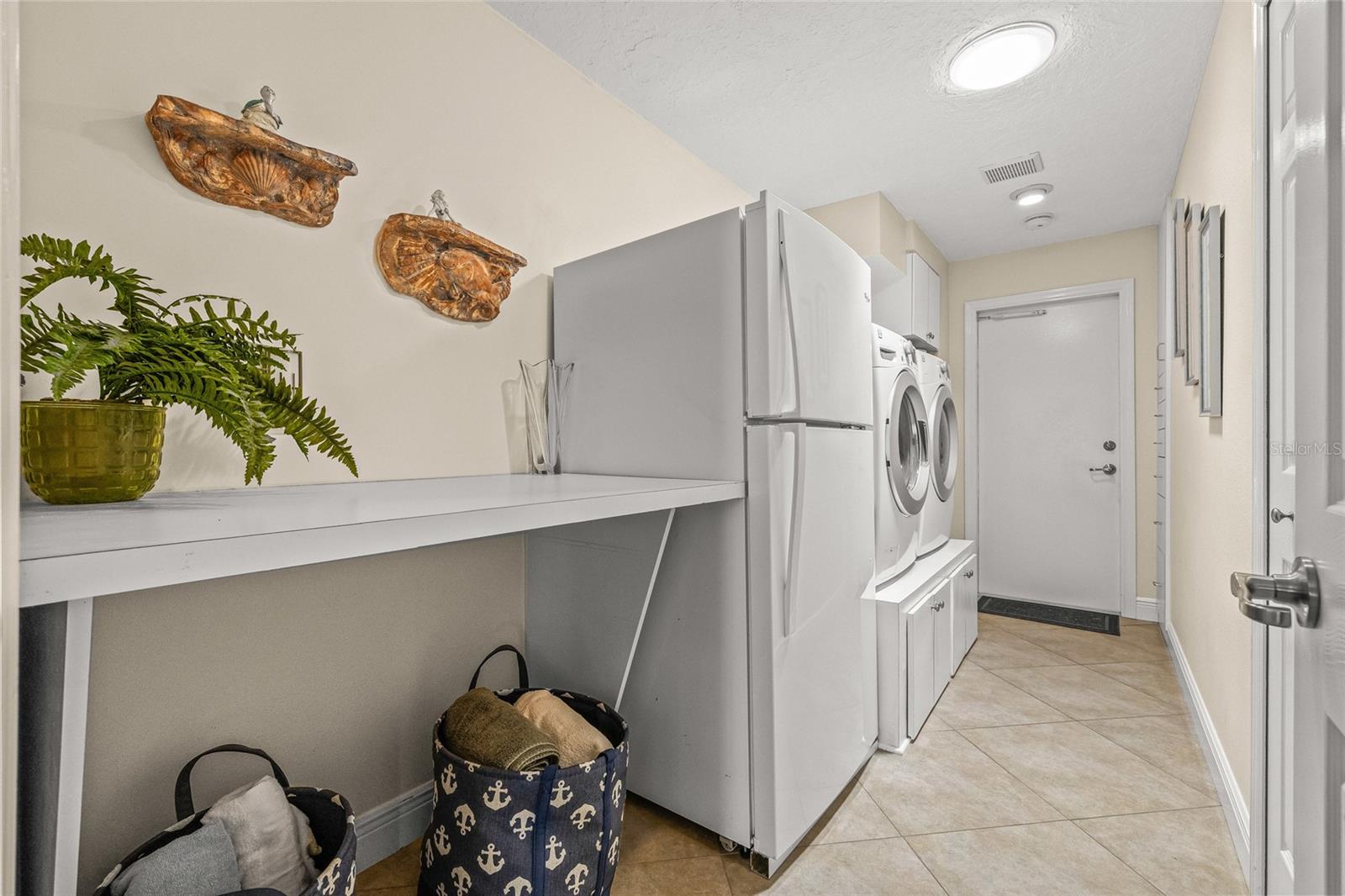Generous laundry room with high-capacity appliances and an extra refrigerator.