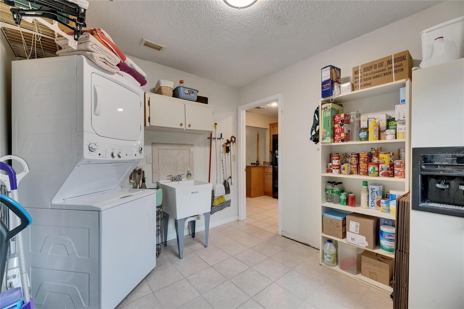 Utility Room has a stackable washer/dryer, laundry sink and extra refrigerator.