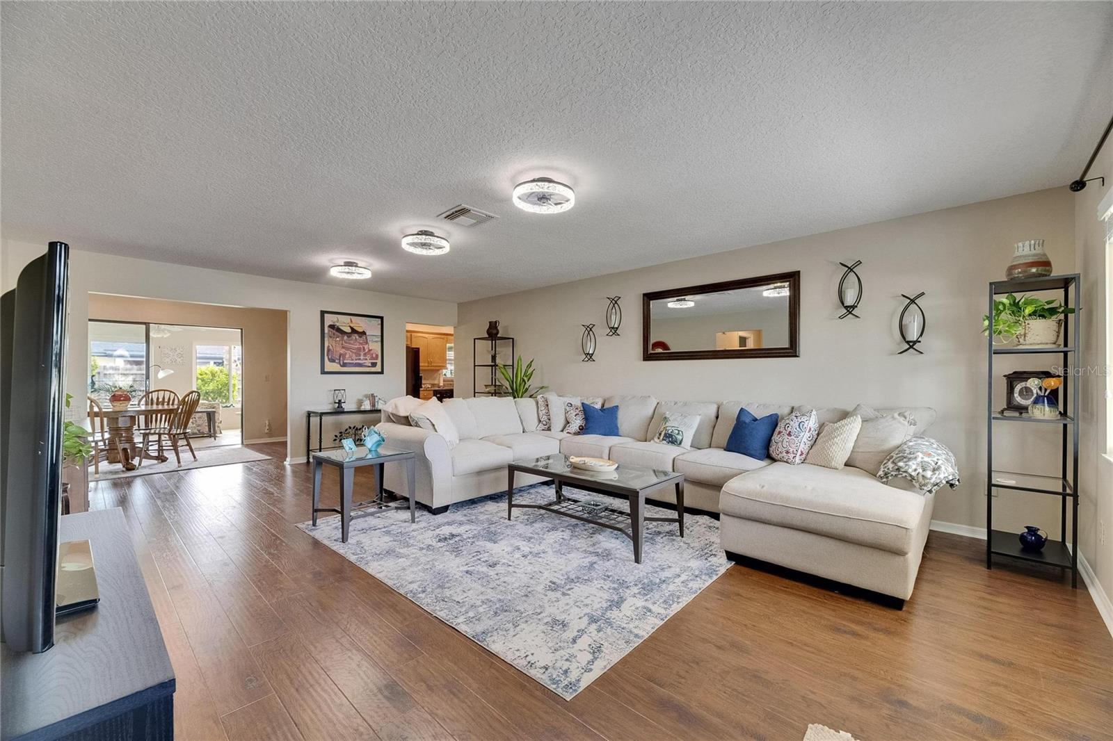 Spacious living room with three led ceiling fans.  Sofa stays