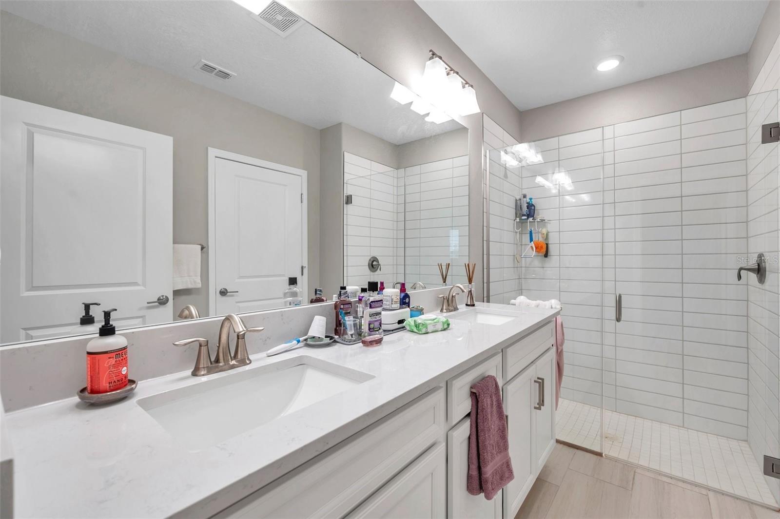 Primary bathroom with dual sinks, plenty of counter space and walk-in shower