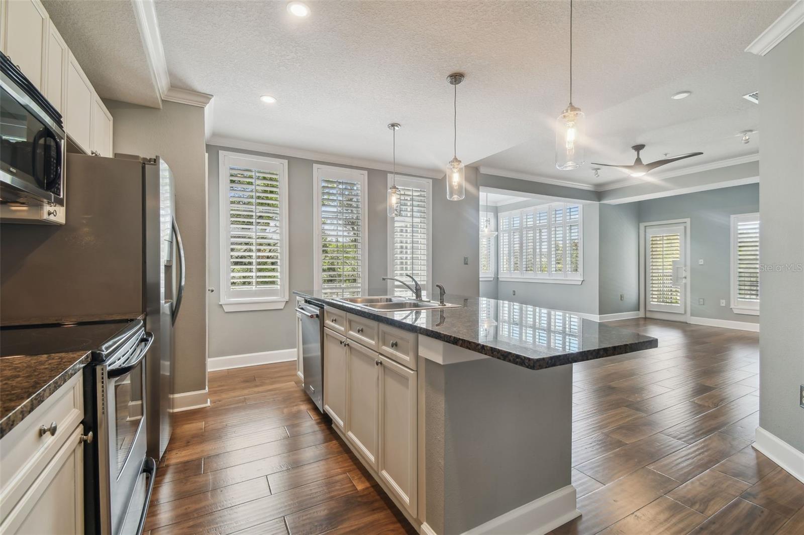 View of open floor plan combining kitchen, dining and living rooms.