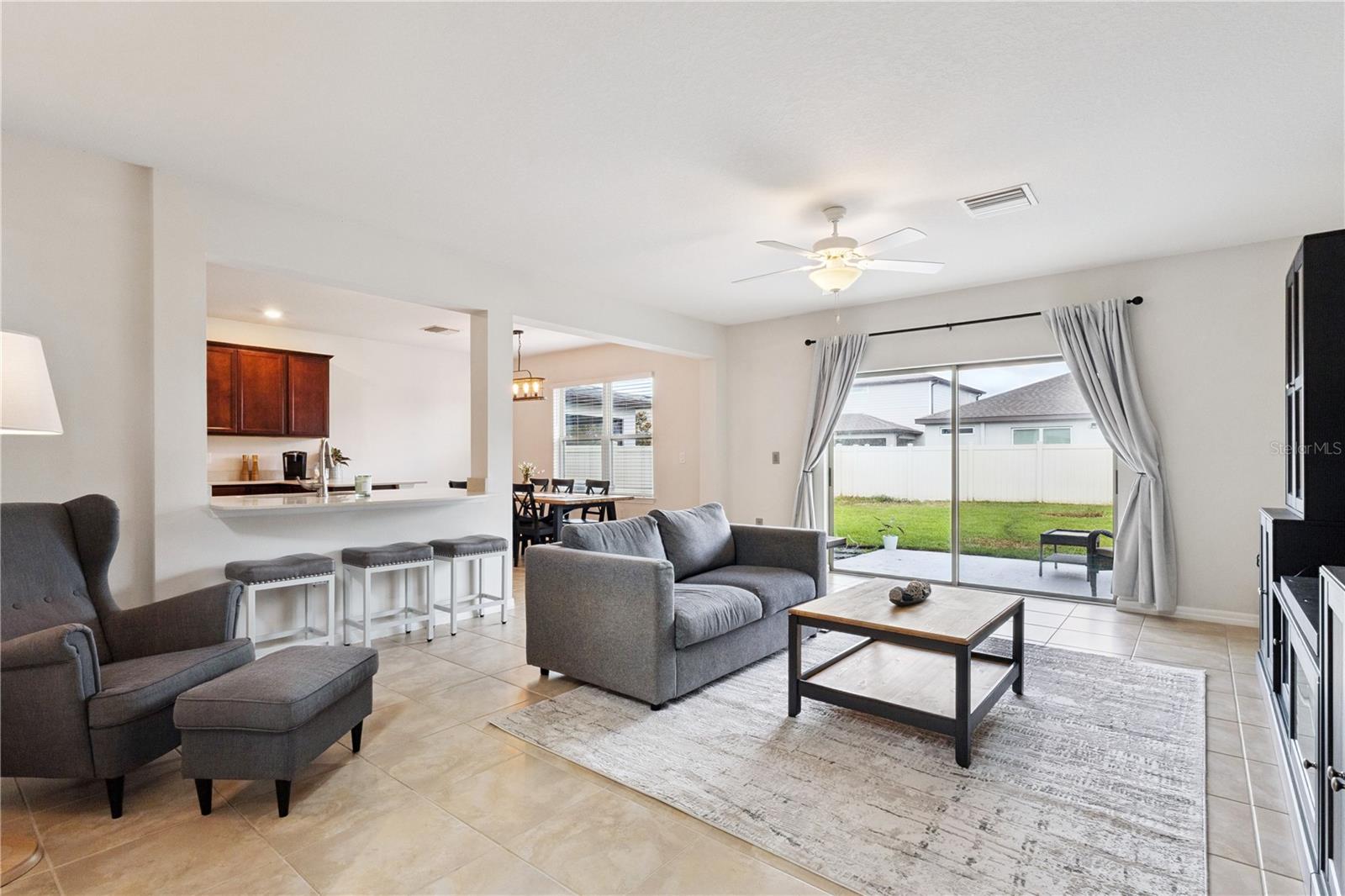 Living room with breakfast bar to the kitchen and sliding glass doors opening to the backyard