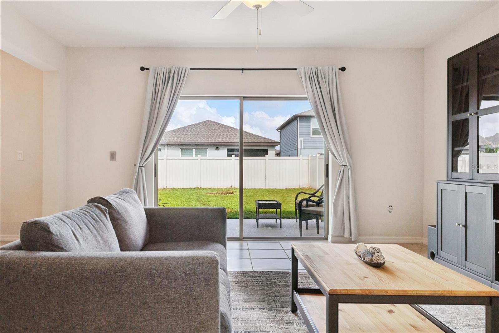 Sliding glass doors leading from the living room to the backyard