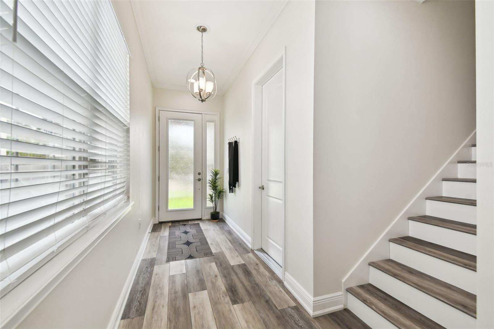 Alternate view of foyer - custom lights - blinds on each window, Luxury laminate wood looking floor throughout entire home.