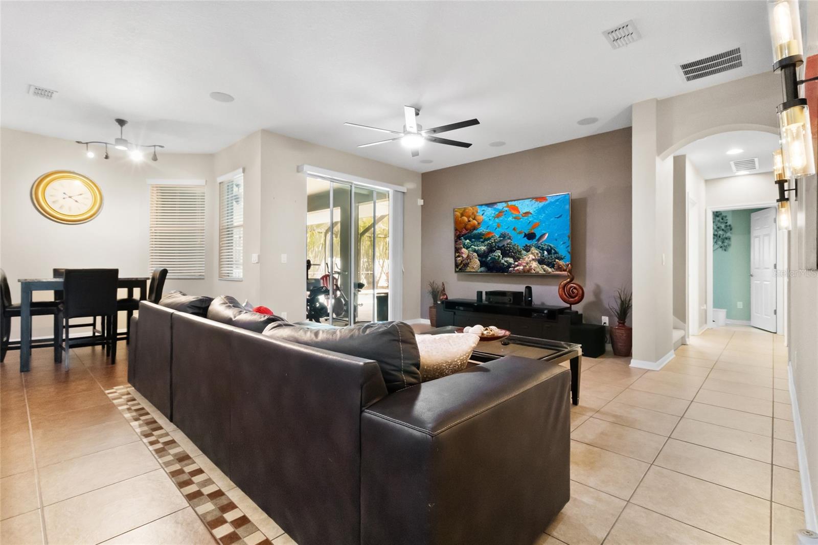 Details abound in this home. Arched door ways, custom tile, and here is another set of sliders leading out to the pool area.