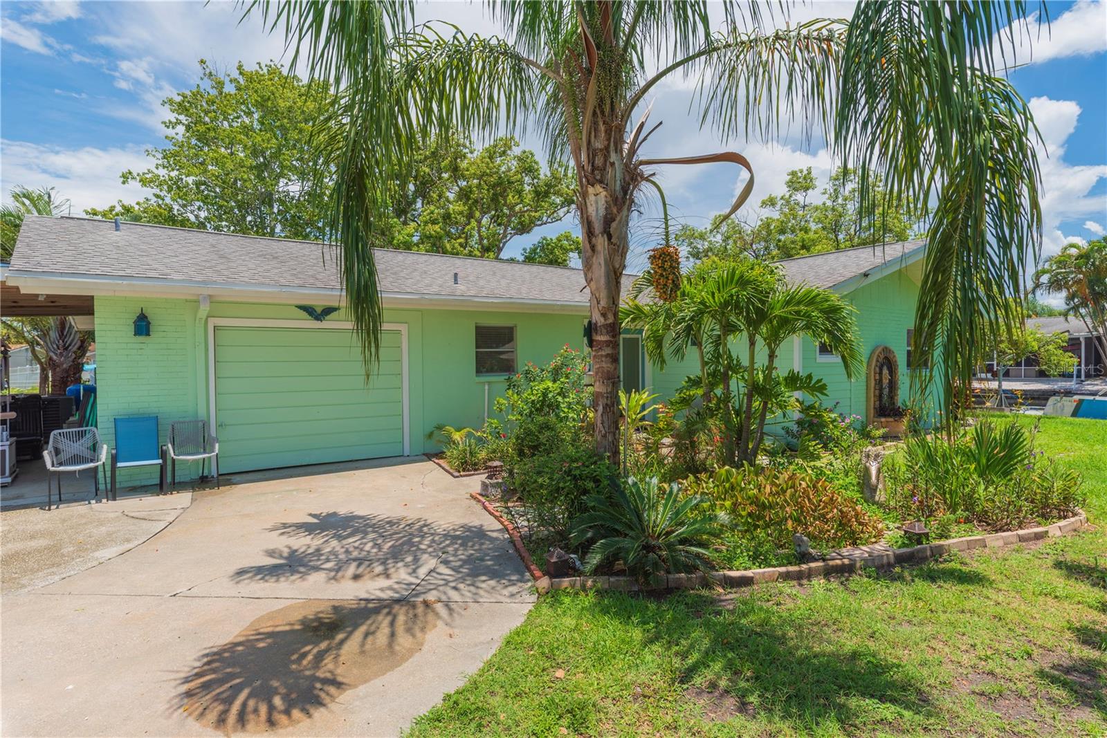 Front yard and driveway with garage and carport.
