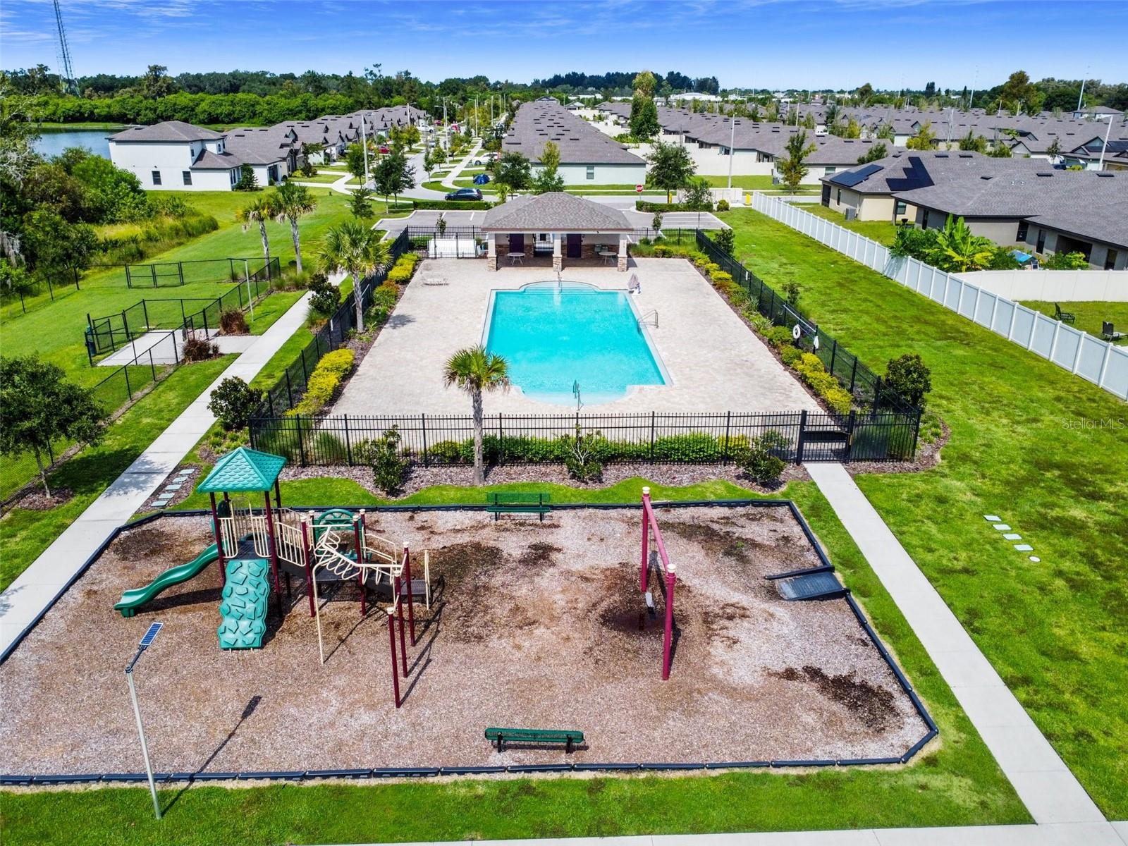 Playground, dog park and back view of community pool