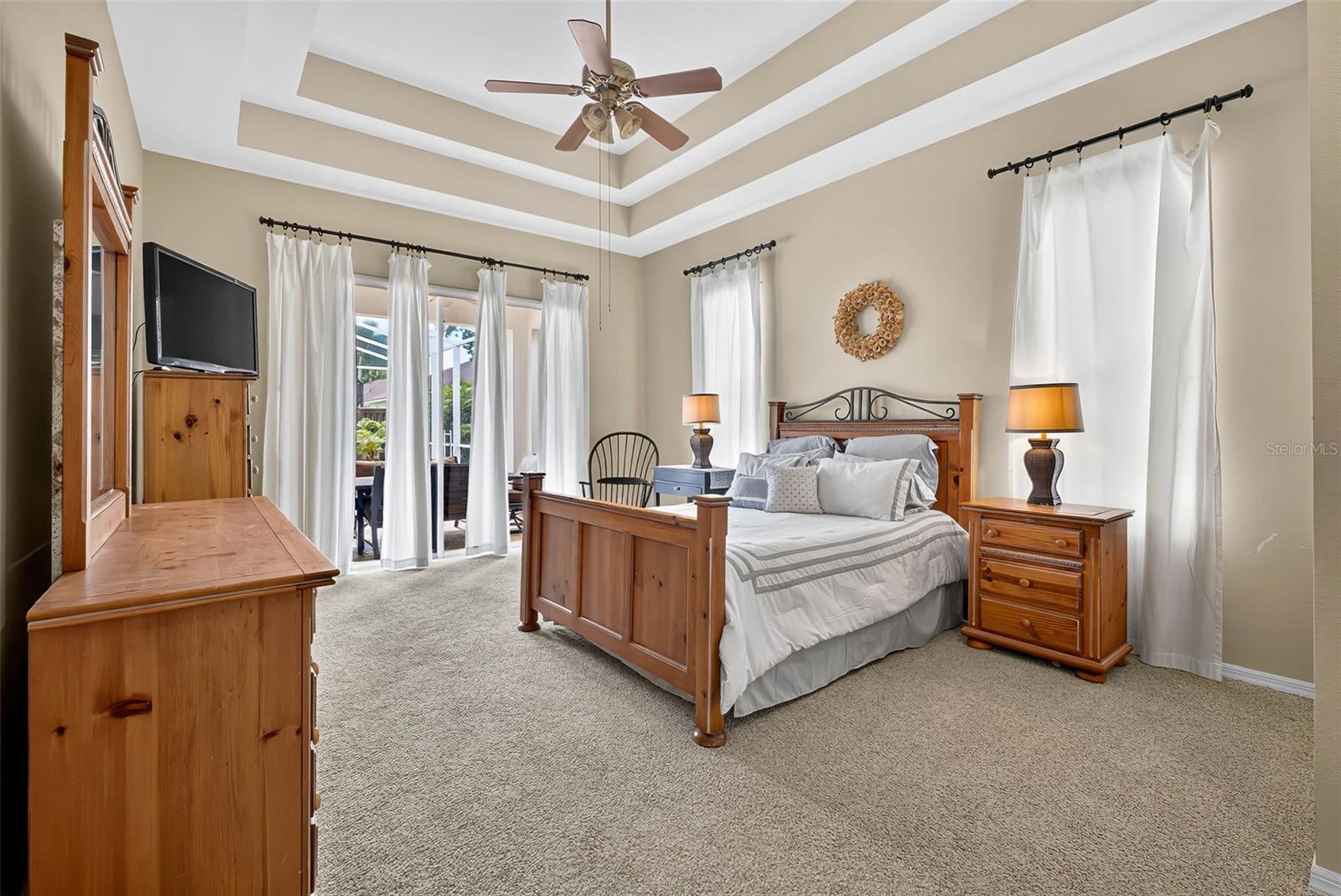 Primary Bedroom with double tray ceiling and access to pool