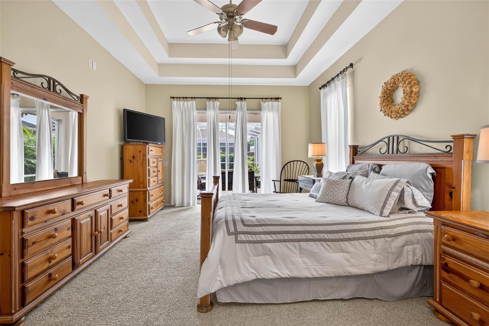 Primary Bedroom with double tray ceiling and access to pool