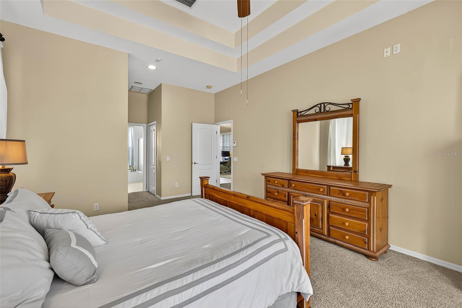 Primary Bedroom with double tray ceiling and access to pool