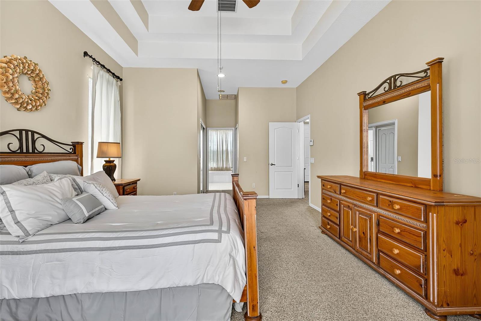Primary Bedroom with double tray ceiling and access to pool