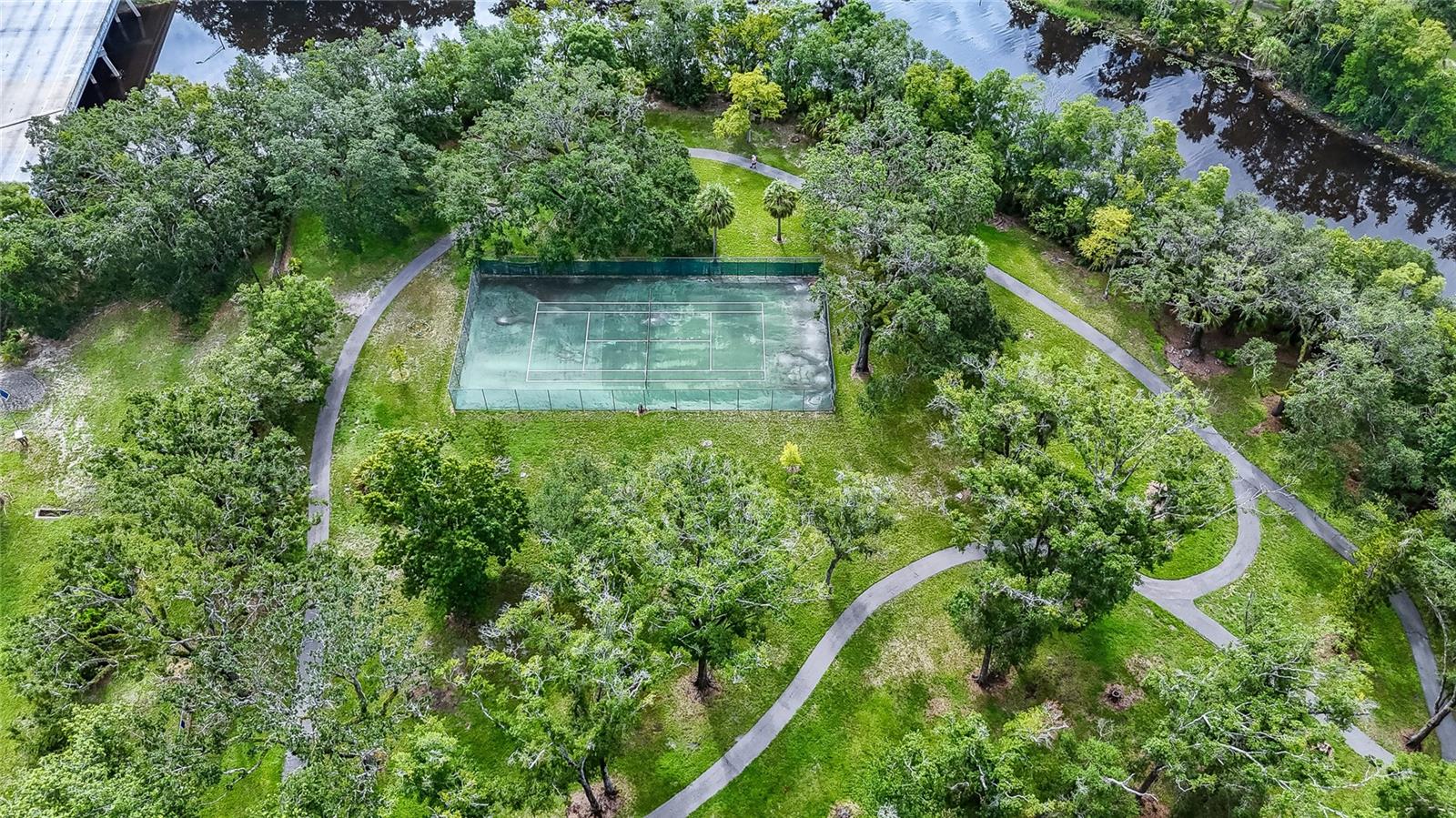 gated park along river with tennis courts
